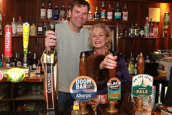 Rachel Gilmour pulling a pint behind a traditional pub bar