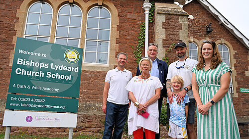 Rachel Gilmour and representatives from Bishops Lydeard Church School and Bishops Lydeard Parish Council outside of the school building